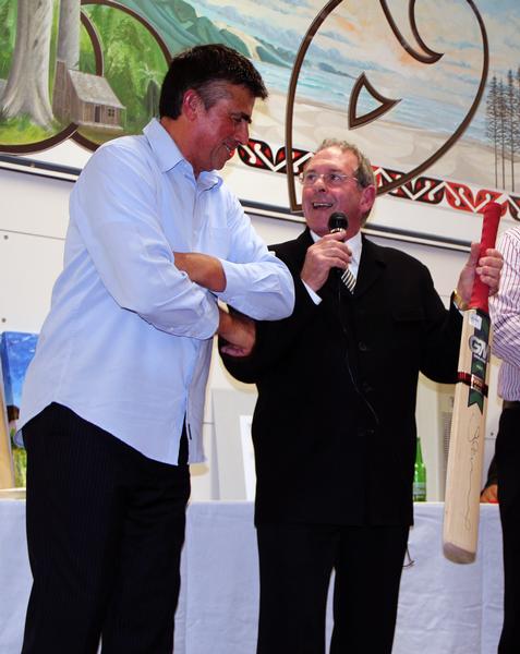 A cricket bat signed by Stephen Fleming and donated by Monty Knight, right, was auctioned for $420.
